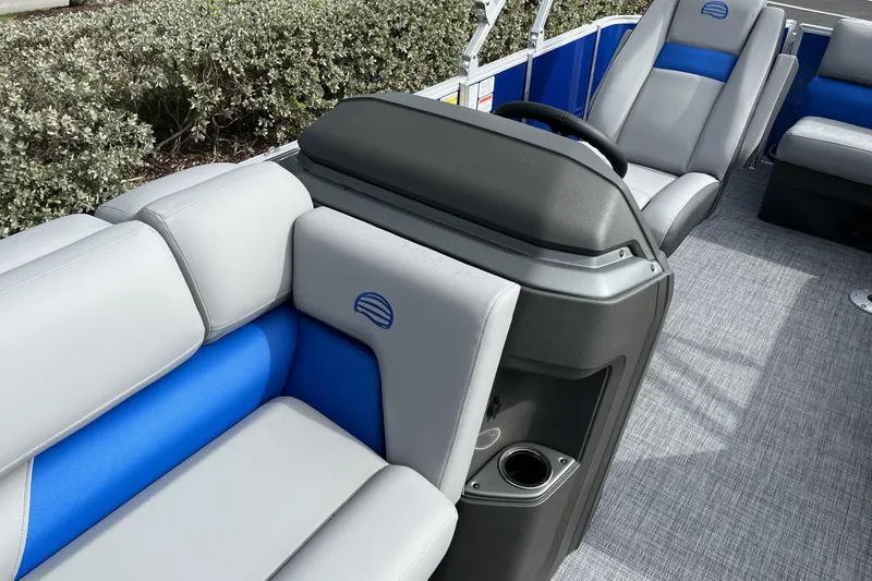 Slide: The Image of 2026 Sun Tracker Party Barge 20 DLX interior with gray and blue seating, steering console. - 103