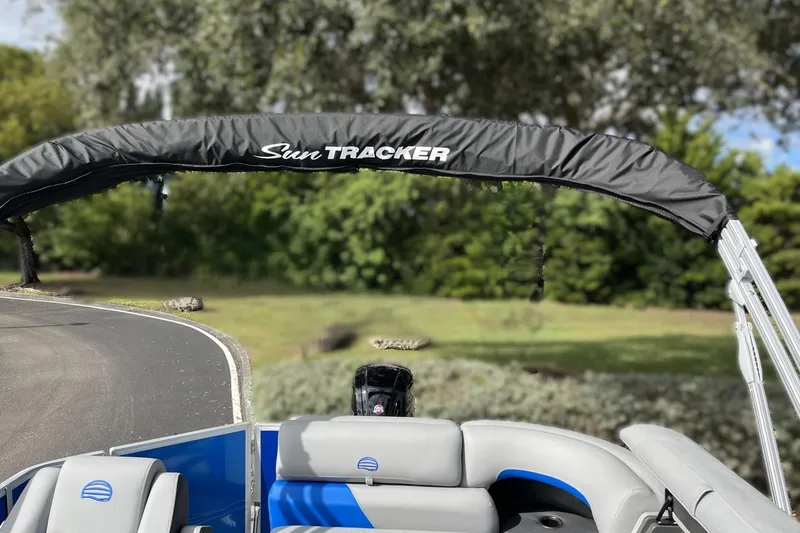 Slide: The Image of 2026 Sun Tracker Party Barge 20 DLX pontoon boat with canopy, parked outdoors. - 93