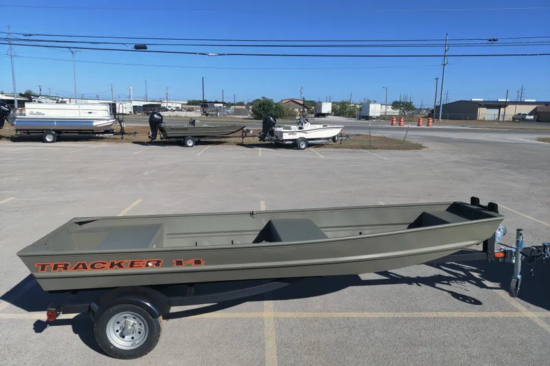 The Image of 2026 Tracker Grizzly 14 Jon boat on trailer in parking lot, clear sky background. - 0