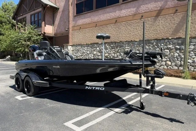 Slide: The Image of 2026 Nitro Z18 Pro boat parked in a lot, featuring sleek black design and dual-axle trailer. - 2