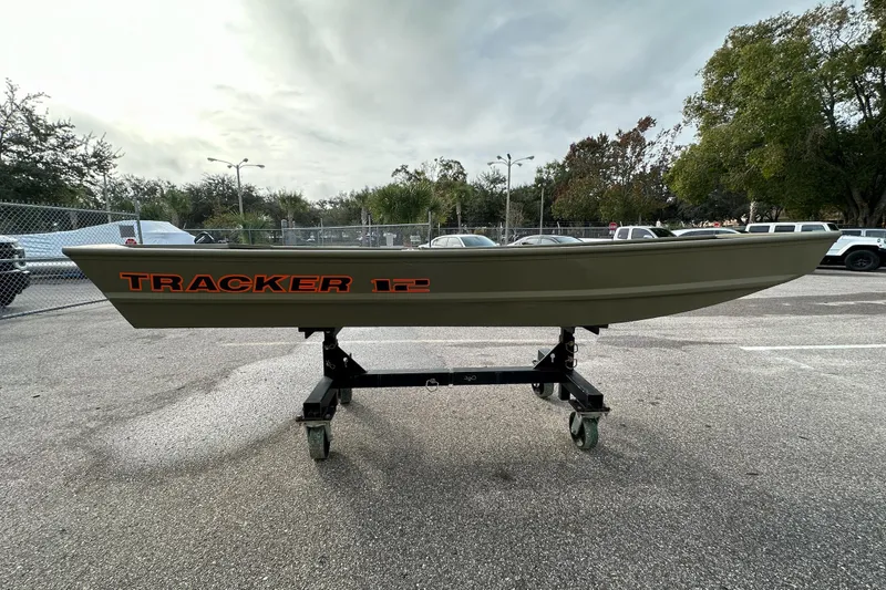 Slide: The Image of 2026 Tracker Grizzly 12 Jon boat on a wheeled stand in a parking lot. - 2
