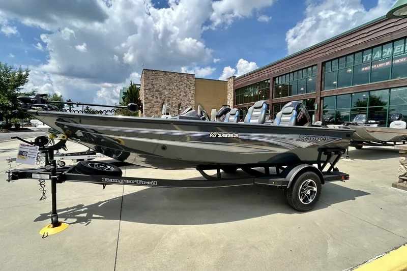 The Image of 2026 Ranger VS1682SC Angler boat on trailer outside dealership under cloudy sky. - 0
