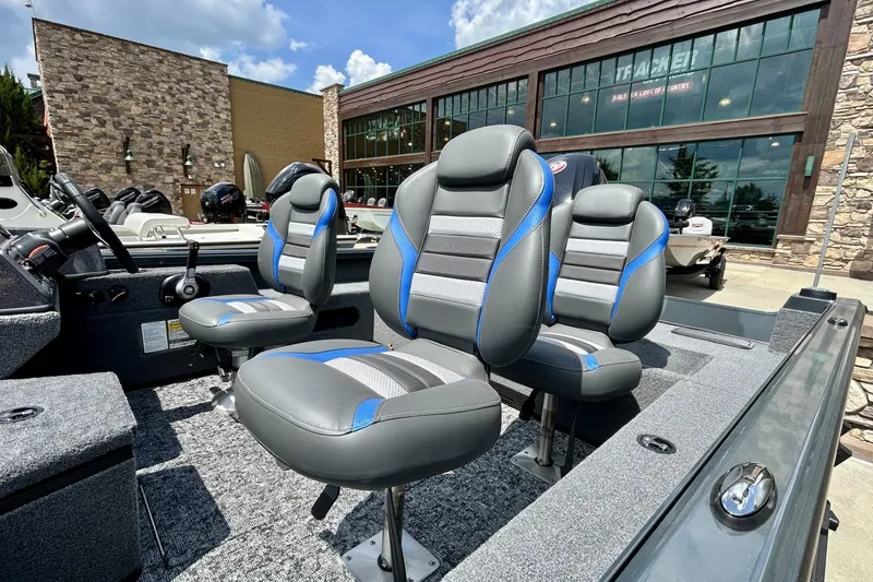 Slide: The Image of 2026 Ranger VS1682SC Angler boat interior with gray and blue seating, parked outdoors. - 4