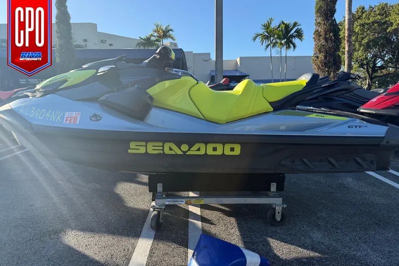 Slide: The Image of 2021 Sea-Doo GTI SE 130 jet ski with vibrant yellow seat, parked outdoors. - 0