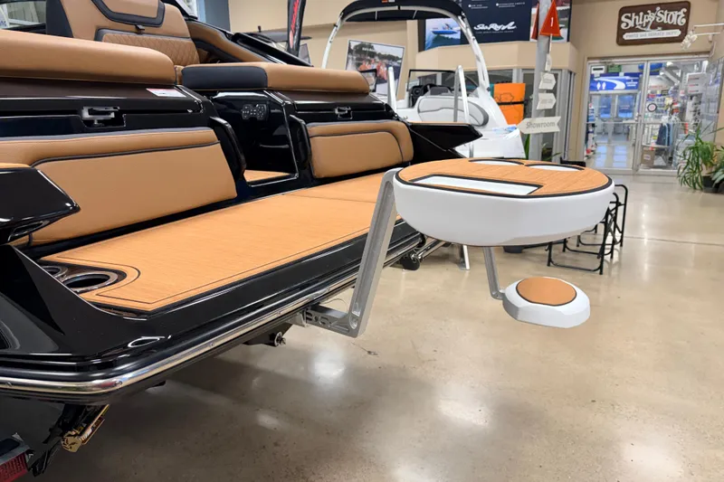 Slide: The Image of 2026 Yamaha Boats 275SD interior with tan seating and modern table in showroom. - 8