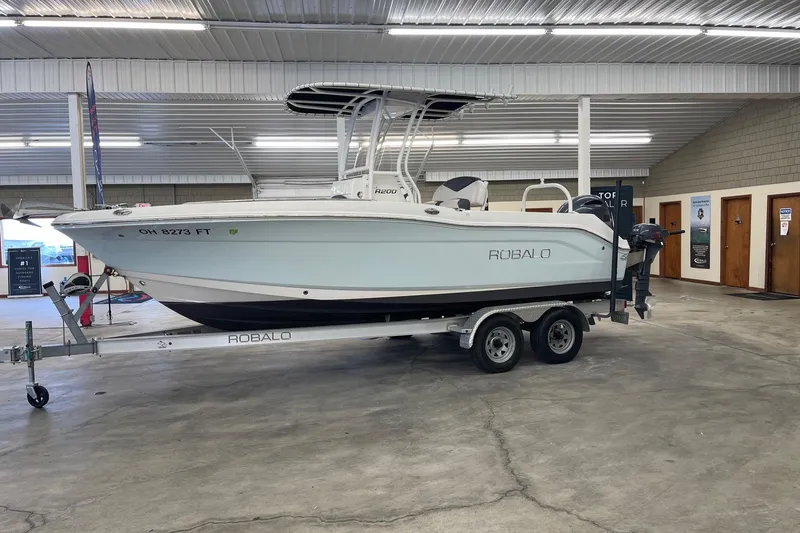 The Image of 2018 Robalo R200 Center Console boat on trailer in indoor showroom. - 0