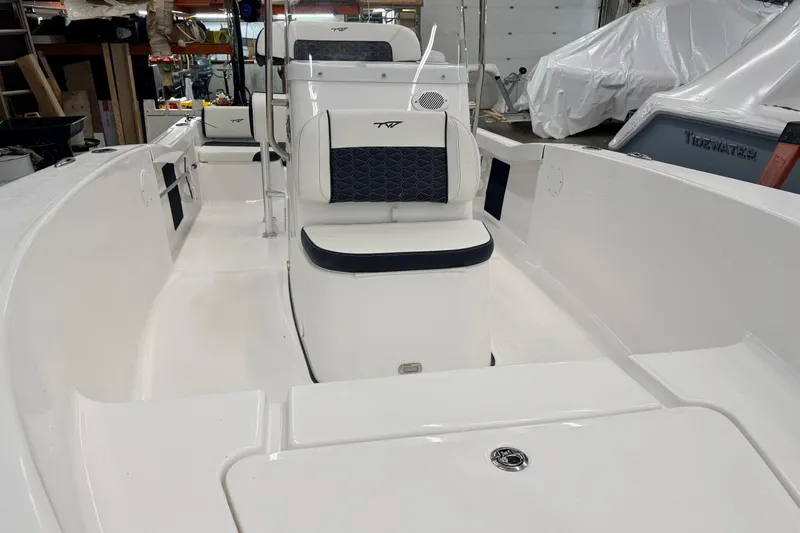 Slide: The Image of 2026 Tidewater 180 CC Adventure boat interior with seating and console in a warehouse. - 18
