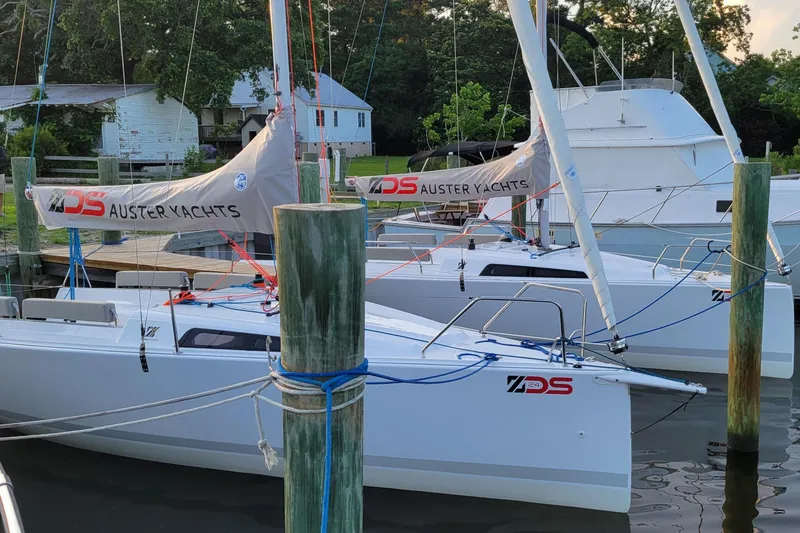 The Image of Sailboats docked at a marina with lush greenery in the background. - 1