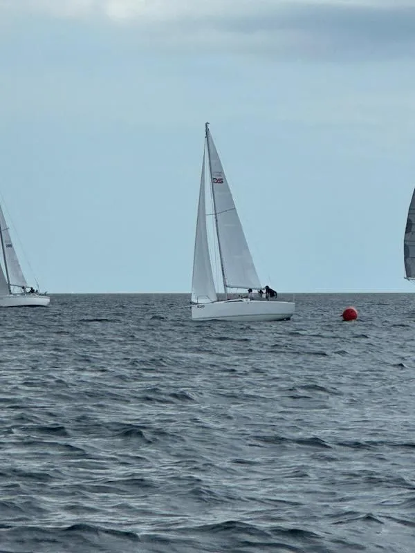 Slide: The Image of Sailboats on the ocean with a buoy, under a cloudy sky. - 30