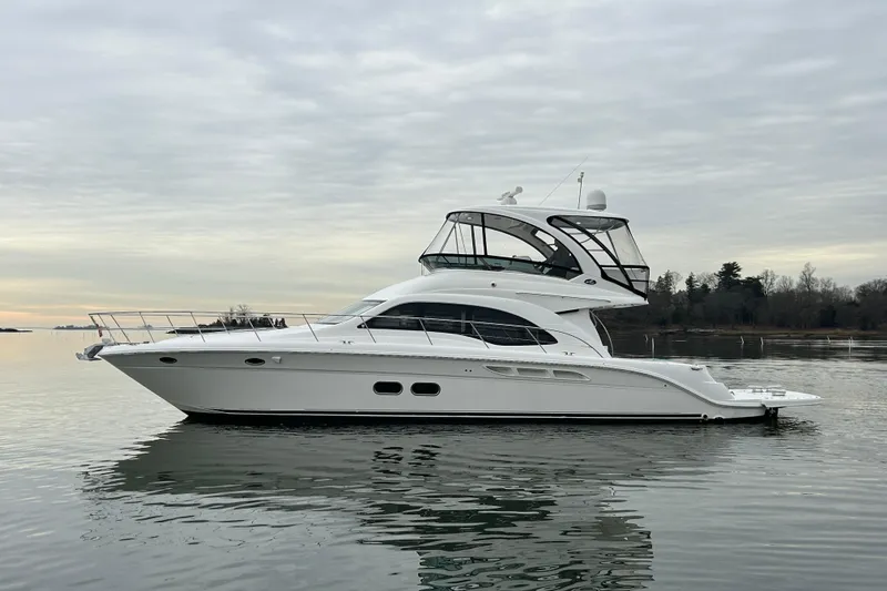 The Image of 2008 Sea Ray 52 Sedan Bridge yacht on calm water under cloudy sky. - 0