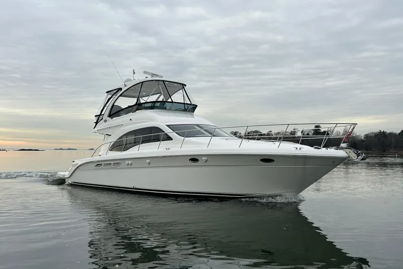 Slide: The Image of 2008 Sea Ray 52 Sedan Bridge yacht cruising on calm waters under cloudy skies. - 2