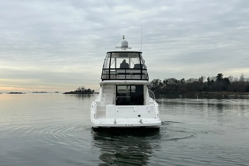 Slide: The Image of 2008 Sea Ray 52 Sedan Bridge yacht on calm water, overcast sky. - 4