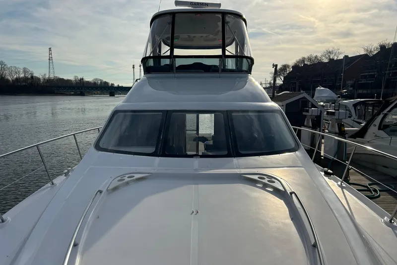 Slide: The Image of 2008 Sea Ray 52 Sedan Bridge yacht docked by the water on a sunny day. - 6