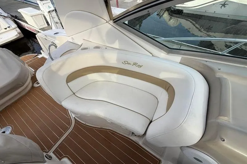 Slide: The Image of 2003 Sea Ray 320 Sundancer boat interior with white seating and wood flooring. - 10