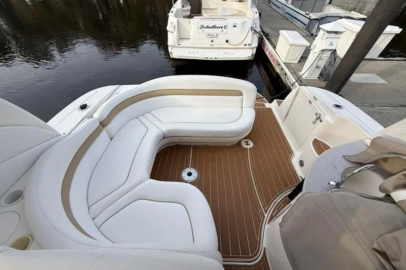 Slide: The Image of 2003 Sea Ray 320 Sundancer boat with white seating and teak deck at a marina. - 11