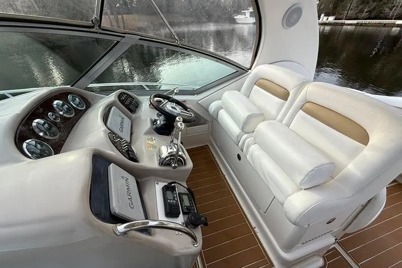 Slide: The Image of 2003 Sea Ray 320 Sundancer helm with white seating and control panel. - 12