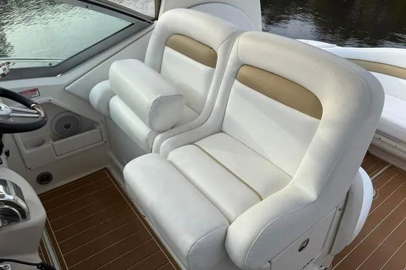 Slide: The Image of 2003 Sea Ray 320 Sundancer cockpit with white leather seats and wooden flooring. - 13