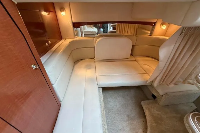 Slide: The Image of Interior of 2003 Sea Ray 320 Sundancer with beige seating and wood accents. - 16