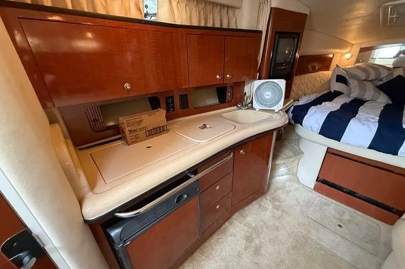 Slide: The Image of Interior of 2003 Sea Ray 320 Sundancer with kitchenette and cozy sleeping area. - 19