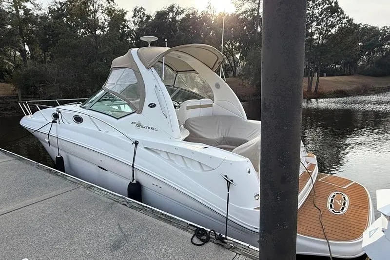 Slide: The Image of 2003 Sea Ray 320 Sundancer docked by a serene waterfront. - 6