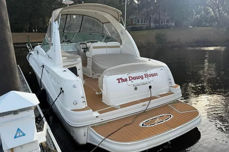 Slide: The Image of 2003 Sea Ray 320 Sundancer docked, featuring spacious deck and elegant design. - 7