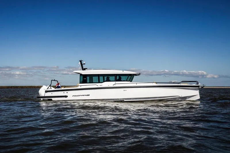 The Image of 2021 Axopar 37 XC Cross Cabin boat cruising on open water under clear blue sky. - 0