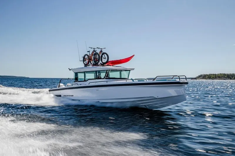 Slide: The Image of 2021 Axopar 37 XC Cross Cabin cruising with bikes and kayak on roof. - 9