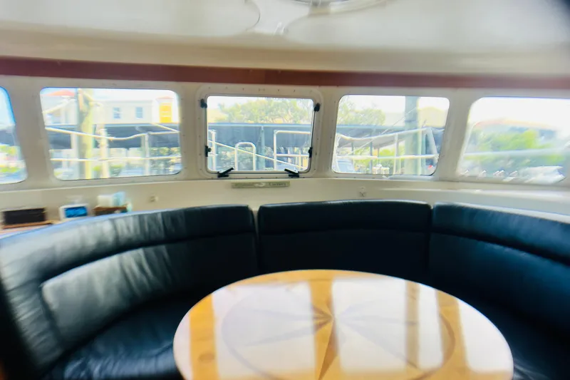 Slide: The Image of Interior of 2007 PDQ MV41 yacht with curved seating and wooden table. - 31