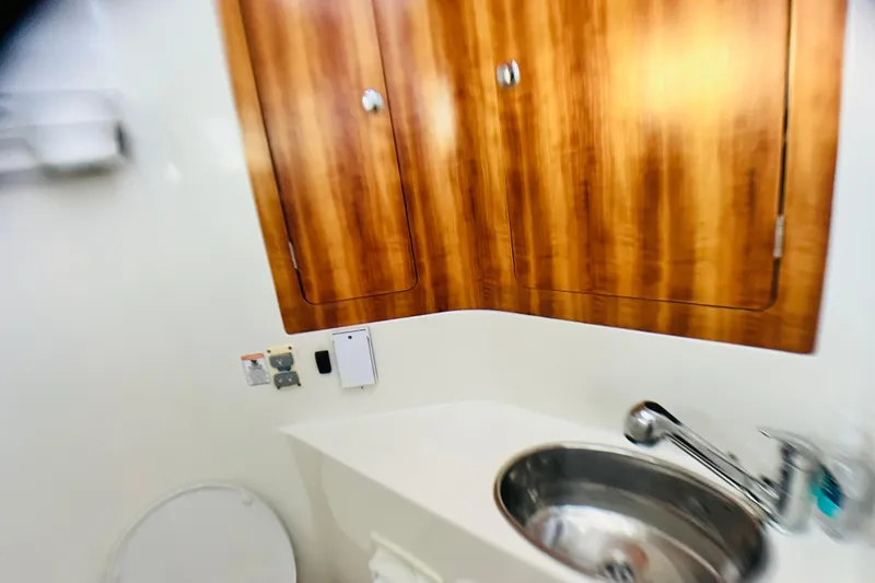 Slide: The Image of Bathroom interior of 2007 PDQ MV41 with wooden cabinets and stainless steel sink. - 46