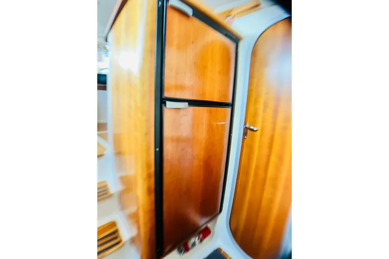 Slide: The Image of Wooden interior of 2007 PDQ MV41 boat, featuring a door and cabinetry. - 48