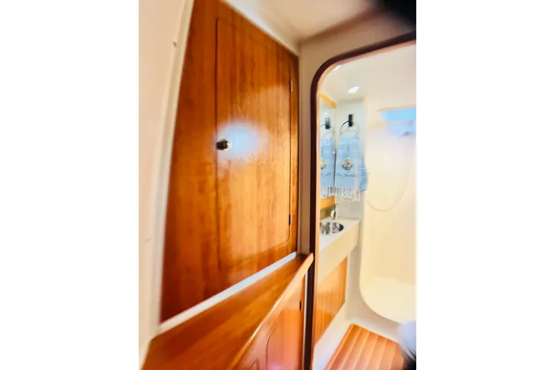 Slide: The Image of Interior of 2007 PDQ MV41 boat featuring wooden cabinetry and a compact bathroom. - 63