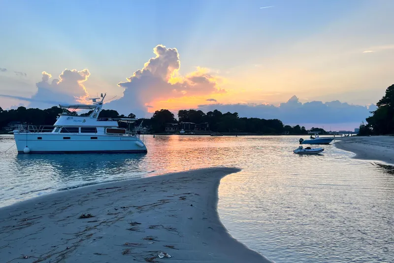 Slide: The Image of Sunset over a tranquil bay with a 2007 PDQ MV41 boat anchored. - 72