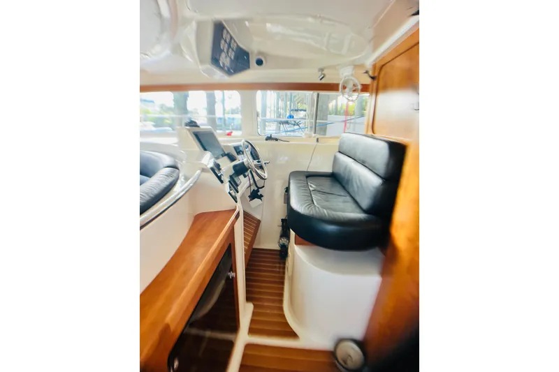 Slide: The Image of Interior of 2007 PDQ MV41 boat with steering wheel and black seating. - 8