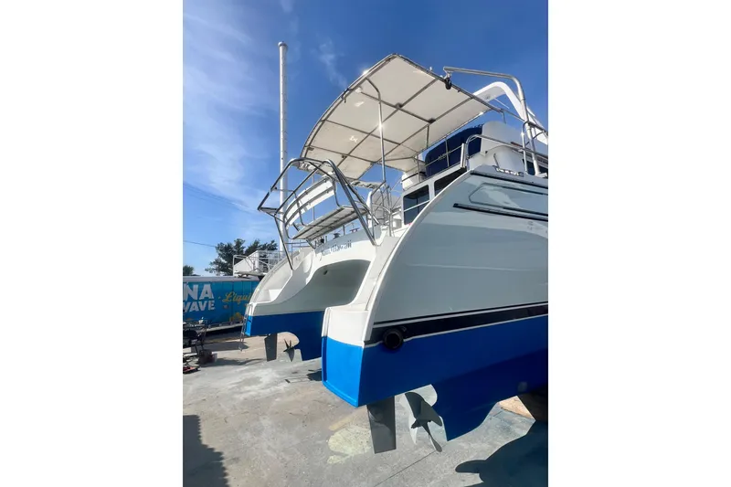 Slide: The Image of 2007 PDQ MV41 catamaran with blue hull, docked under clear sky. - 80