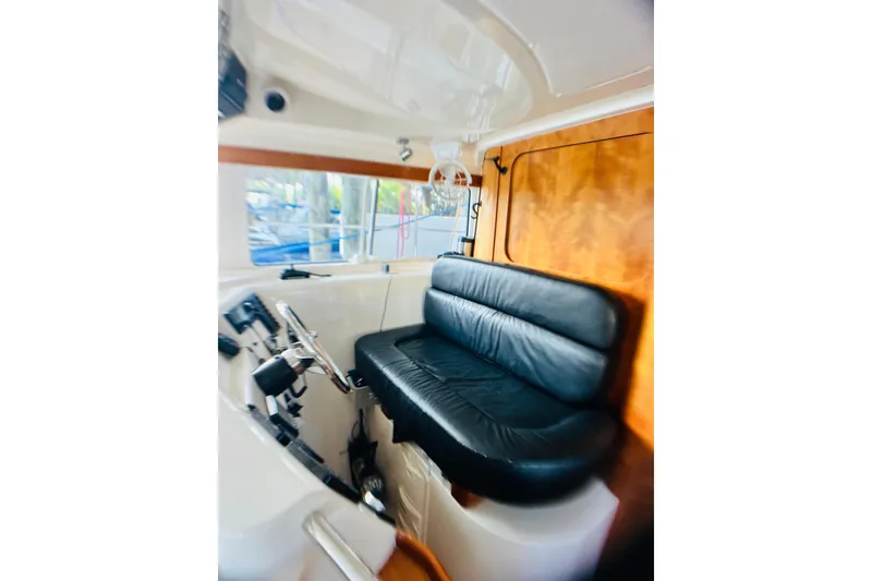 Slide: The Image of Interior of 2007 PDQ MV41 boat with black leather seating and wooden accents. - 9