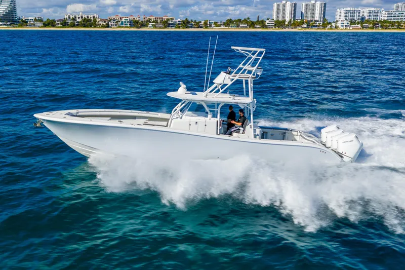 Slide: The Image of 2015 Yellowfin 42 Offshore boat cruising on blue ocean near city skyline. - 13