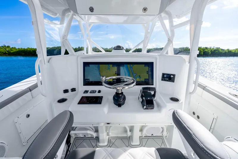 Slide: The Image of 2015 Yellowfin 42 Offshore boat helm with navigation display, steering wheel, and controls. - 26