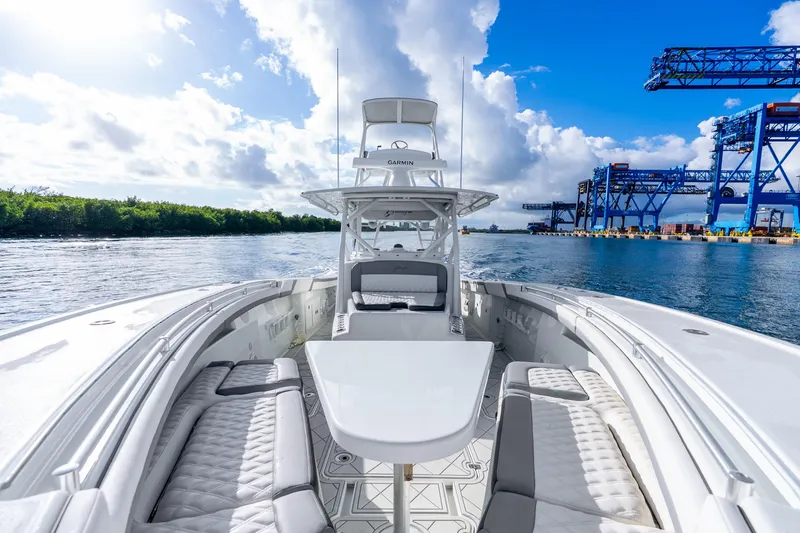 Slide: The Image of 2015 Yellowfin 42 Offshore boat on water, clear sky, industrial port background. - 32