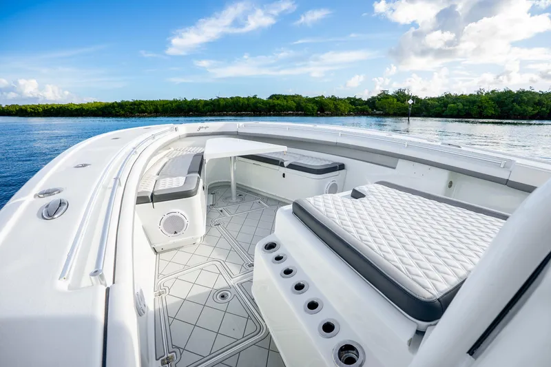 Slide: The Image of 2015 Yellowfin 42 Offshore boat interior with seating, on a calm water backdrop. - 33