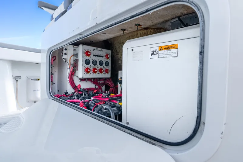Slide: The Image of Electrical panel inside 2015 Yellowfin 42 Offshore boat, featuring wiring and warning label. - 38