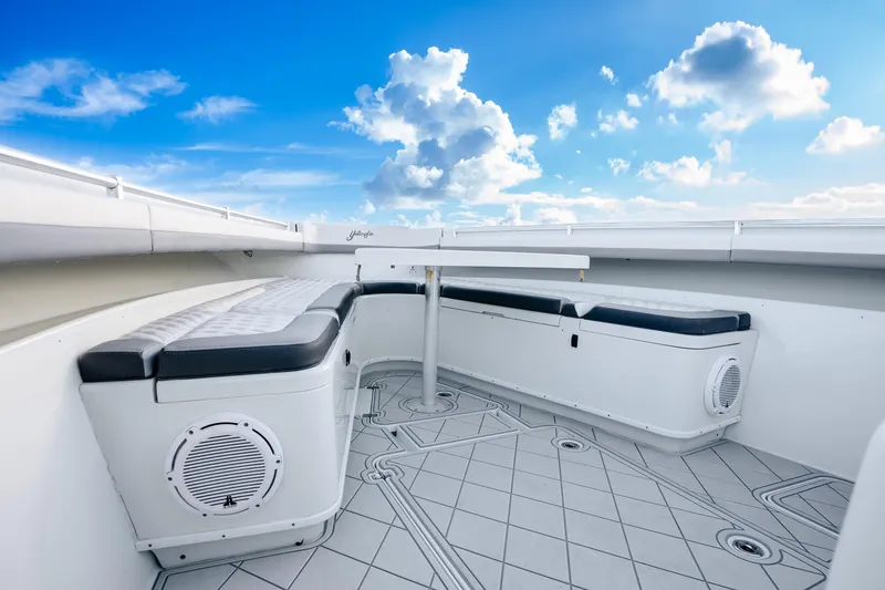 Slide: The Image of 2015 Yellowfin 42 Offshore boat interior with cushioned seating and clear blue sky. - 43