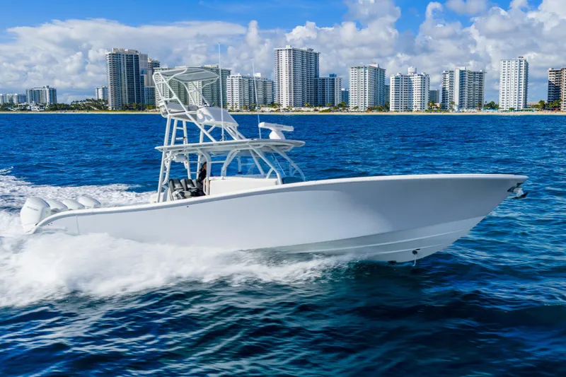 Slide: The Image of 2015 Yellowfin 42 Offshore boat cruising near city skyline on blue ocean waters. - 8