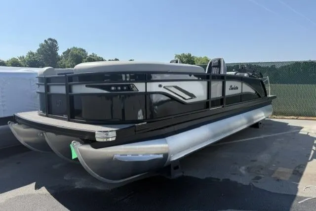 The Image of 2026 Barletta Corsa 23UC pontoon boat in a parking lot, featuring sleek black and silver design. - 0
