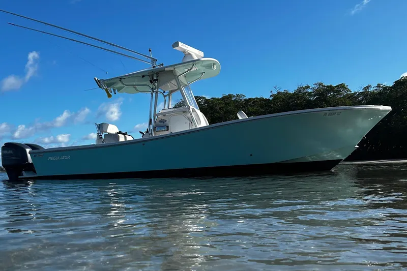 Slide: The Image of 2008 Regulator 26 Forward Seating boat on calm water under clear blue sky. - 3