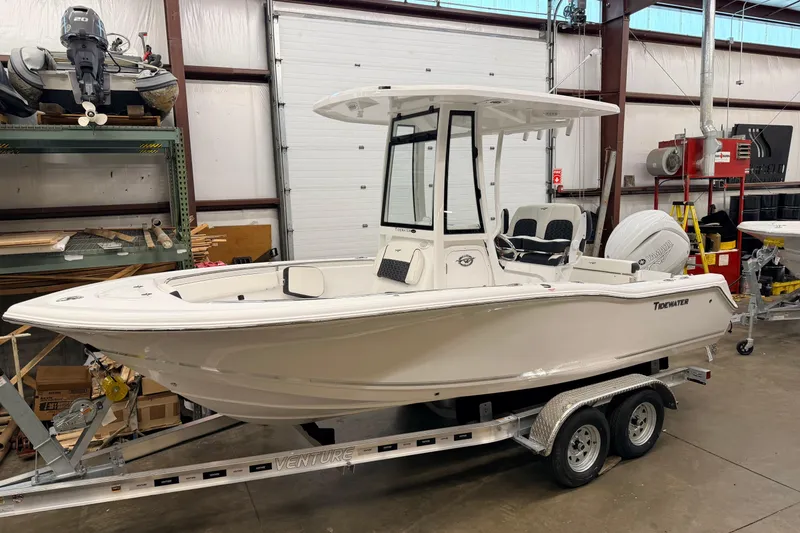 Slide: The Image of 2026 Tidewater 210 CC Adventure boat with Yamaha engine in a warehouse. - 2