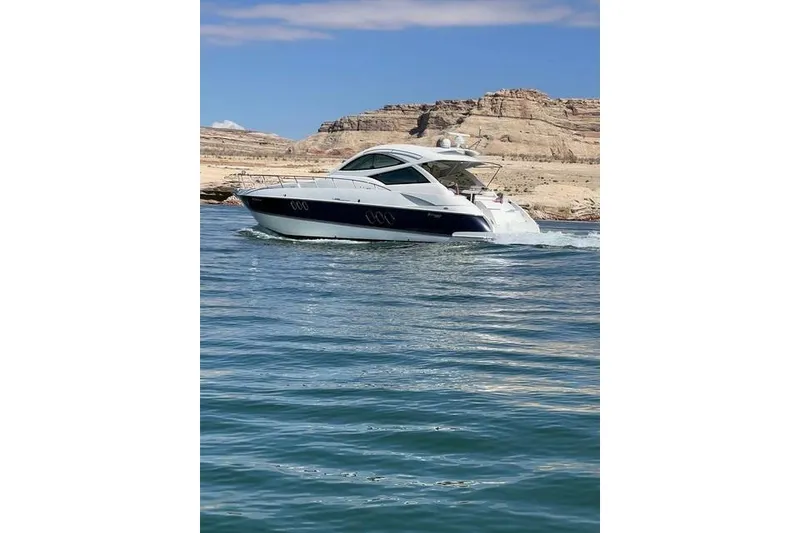 Slide: The Image of 2009 CRUISERS YACHT 520SC navigating scenic waters with rocky cliffs in the background. - 2