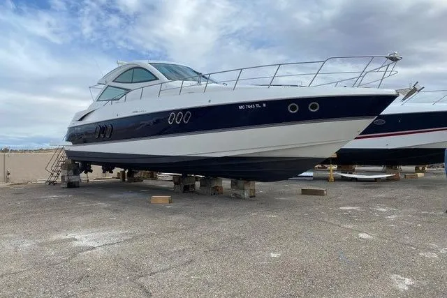 Slide: The Image of 2009 CRUISERS YACHT 520SC on dry dock, sleek design, blue and white hull. - 3