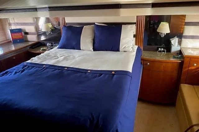 Slide: The Image of Luxurious bedroom interior of 2009 CRUISERS YACHT 520SC with blue bedding and elegant furnishings. - 4