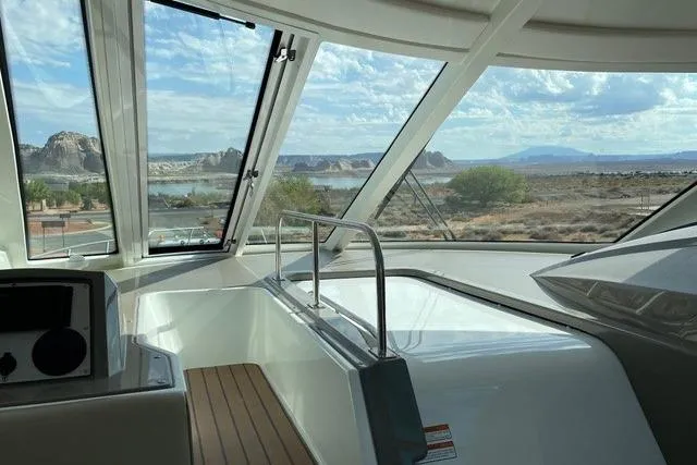 Slide: The Image of Interior view of 2009 CRUISERS YACHT 520SC with scenic landscape through windows. - 6