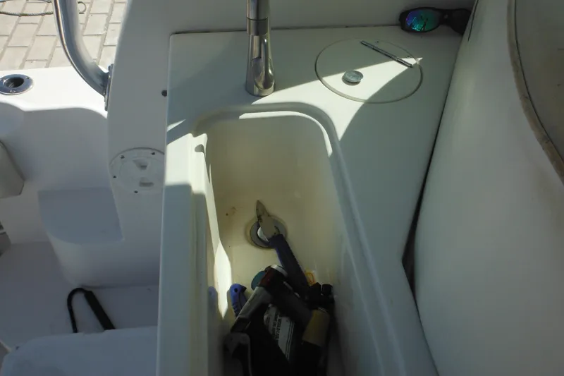 Slide: The Image of 2005 Seaswirl Striper 2901 Walkaround O/B sink area with tools and sunglasses. - 57